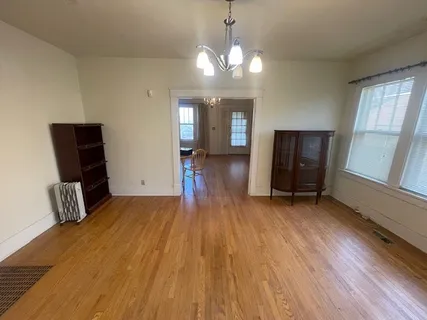 a view of a livingroom with furniture wooden floor and window