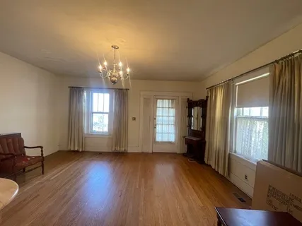 a view of a big room with wooden floor and windows