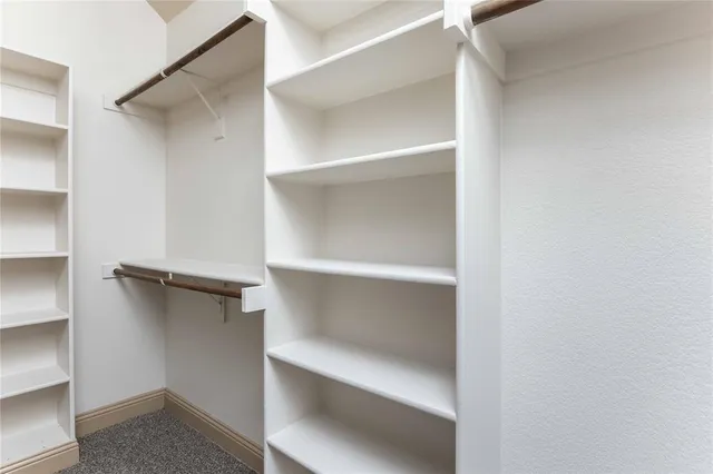 a view of walk in closet with empty racks