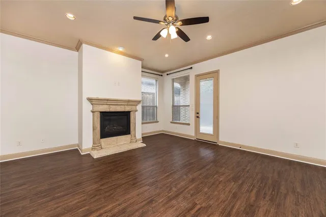 a view of a livingroom with a fireplace a ceiling fan and wooden floor
