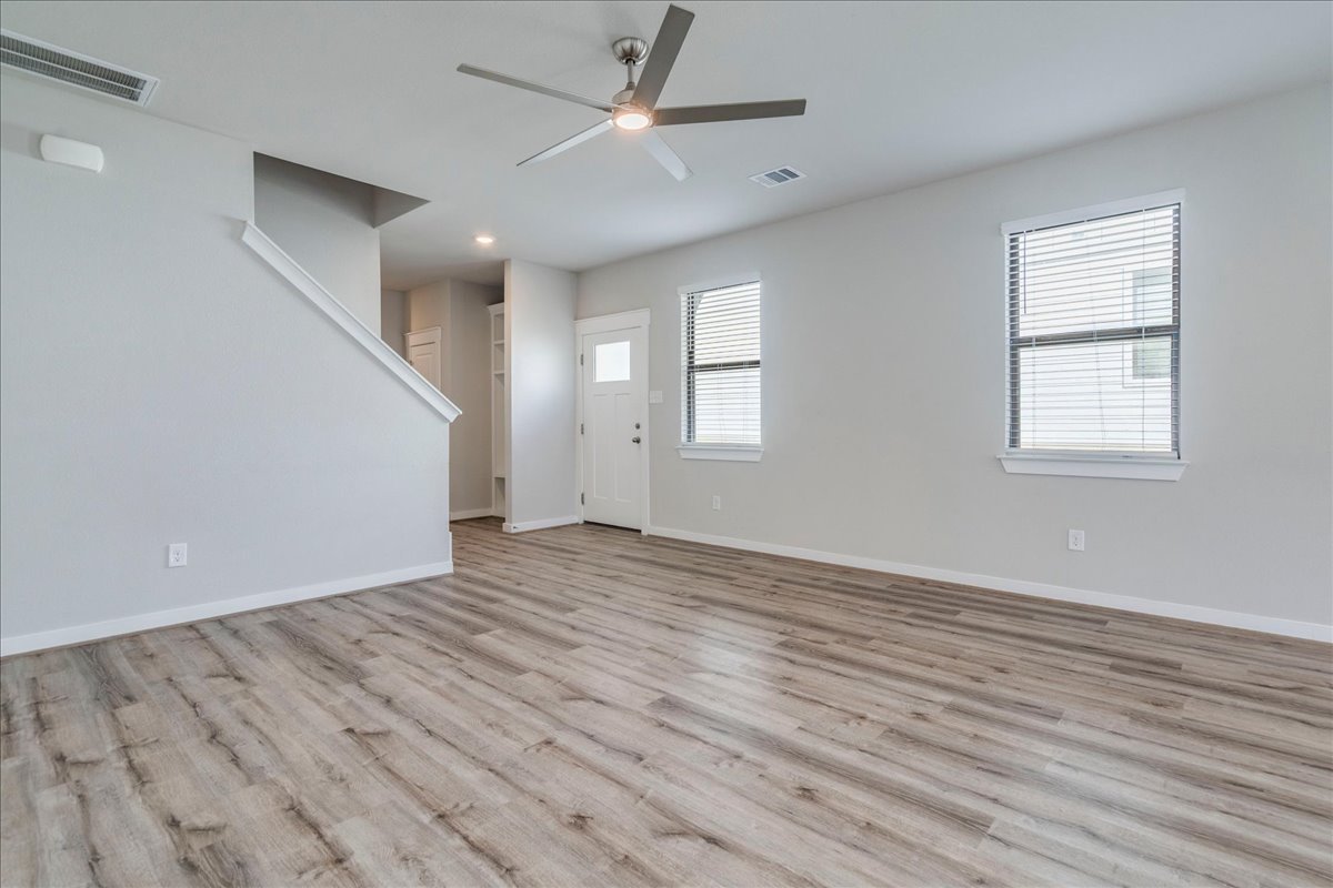 144 Threshing Road, Unit A Buda, TX 78610 - Photo 8 of 35 Living room with ceiling fan and tv mount. LVP flooring throughout the lower level.