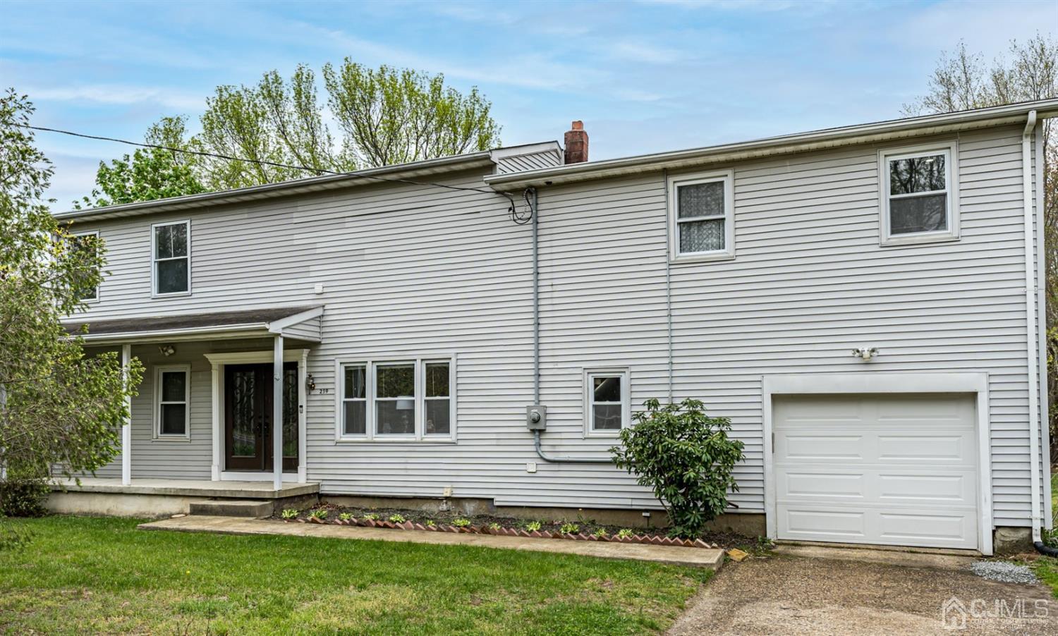259 Spring Valley Road Morganville, NJ 07751 - Photo 1 of 36 a front view of a house with a garden