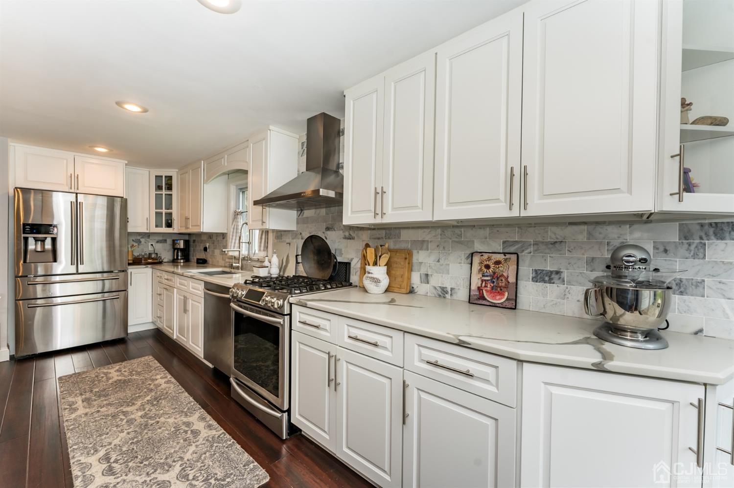 259 Spring Valley Road Morganville, NJ 07751 - Photo 11 of 36 a kitchen with stainless steel appliances granite countertop a sink a stove and a refrigerator