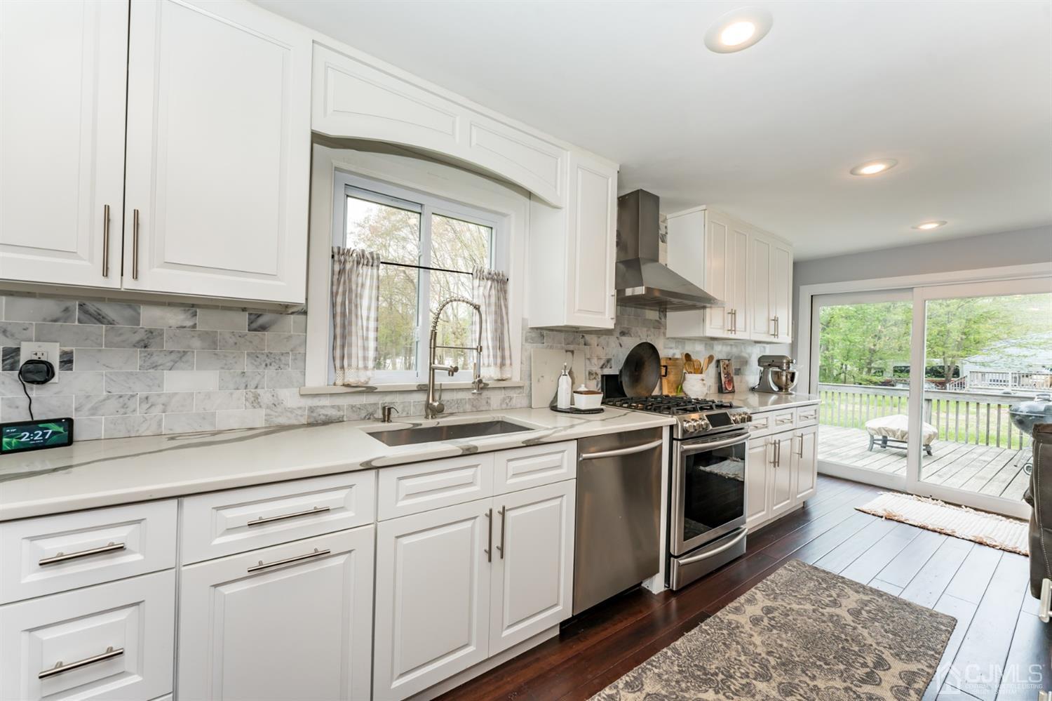 259 Spring Valley Road Morganville, NJ 07751 - Photo 12 of 36 a kitchen with a sink stove and cabinets
