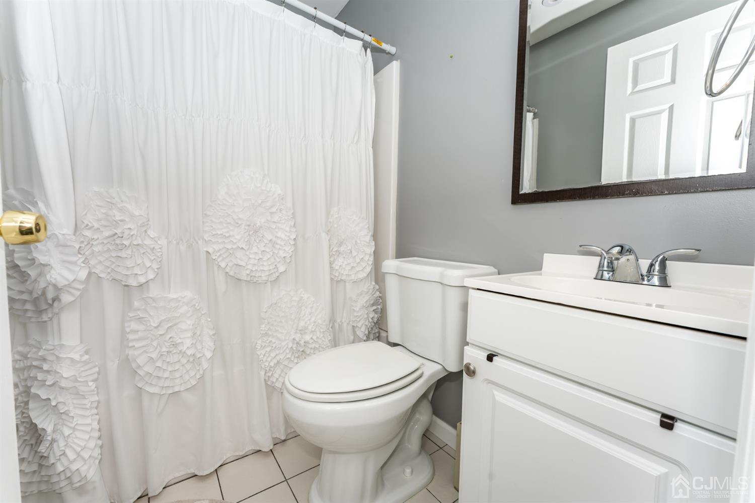 259 Spring Valley Road Morganville, NJ 07751 - Photo 20 of 36 a bathroom with a toilet sink vanity and mirror