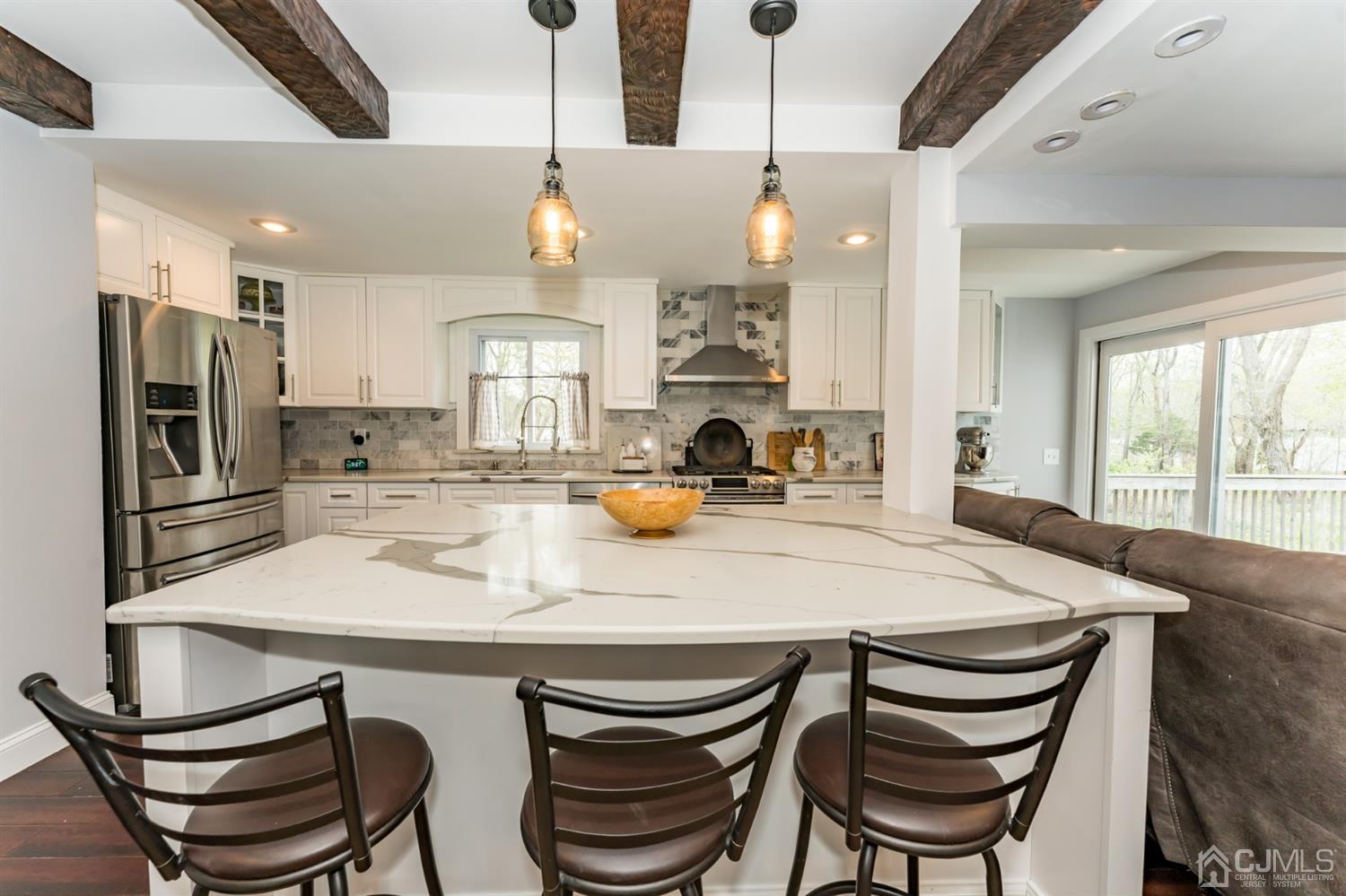 259 Spring Valley Road Morganville, NJ 07751 - Photo 10 of 36 a kitchen with a dining table chairs and refrigerator