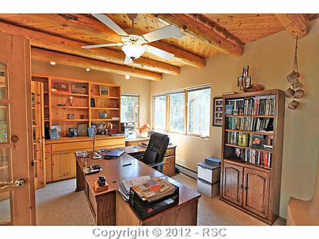 16 West Point Road Colorado Springs, CO 80906 - Photo 14 of 25 The upper level features a large office complete with gas fireplace, beamed ceiling and dramatic double French doors. An enjoyable view through the east facing windows makes working here a joyful retreat. Ample windows provide natural lighting