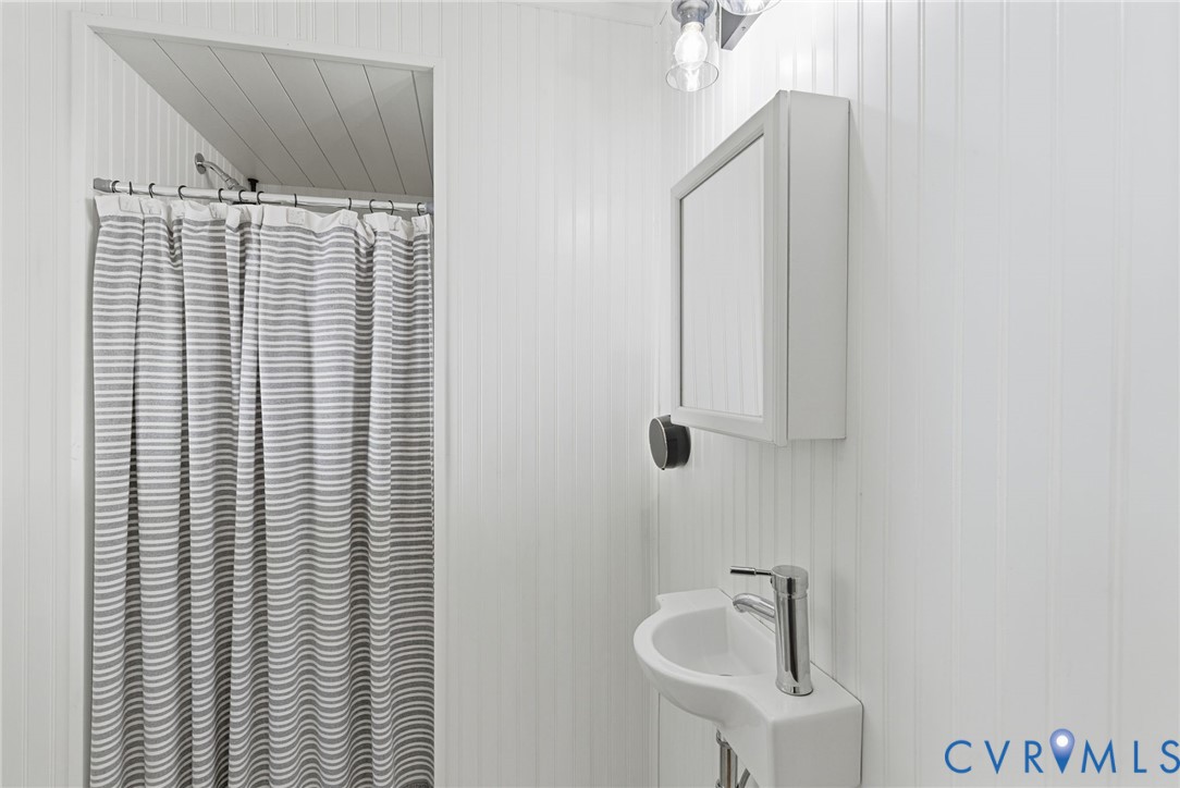 8456 Atlee Road Mechanicsville, VA 23116 - Photo 16 of 28 a bathroom with a sink a mirror and shower curtain