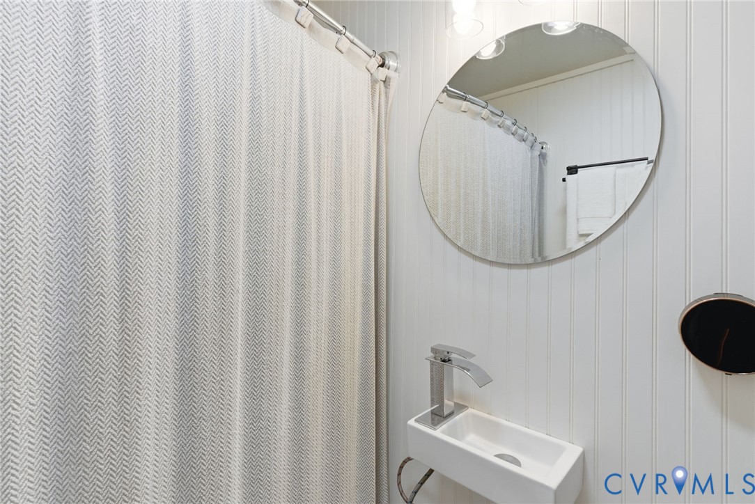 8456 Atlee Road Mechanicsville, VA 23116 - Photo 21 of 28 a bathroom with a sink a mirror and a shower curtain