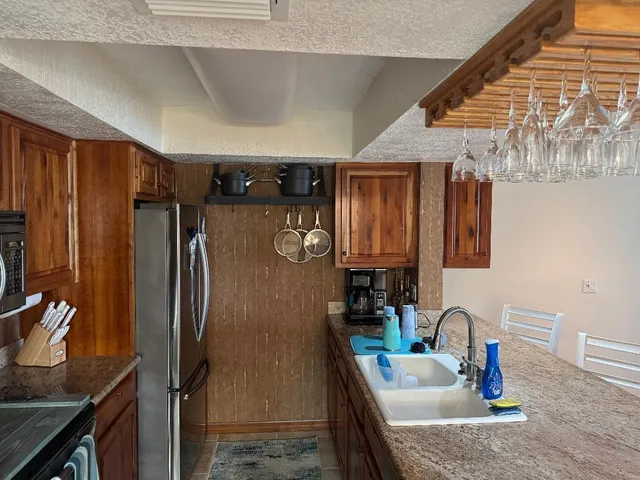 a kitchen with stainless steel appliances granite countertop a sink refrigerator and microwave