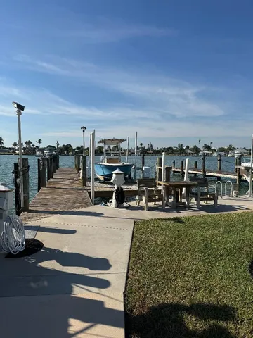 a view of a swimming pool with lawn chairs and iron fence