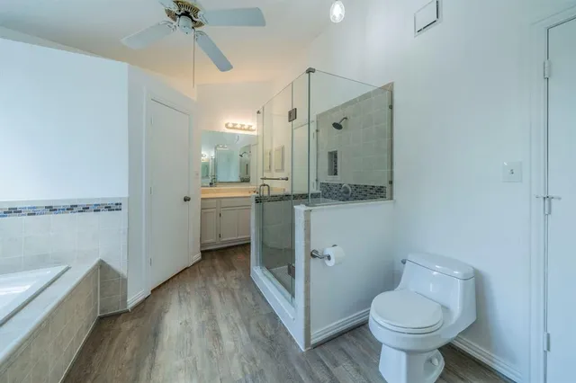 a bathroom with a granite countertop toilet sink and mirror