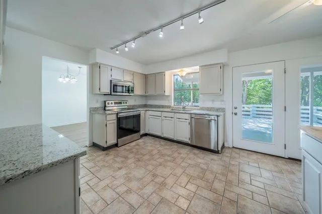 a kitchen with stainless steel appliances granite countertop a stove sink and cabinets