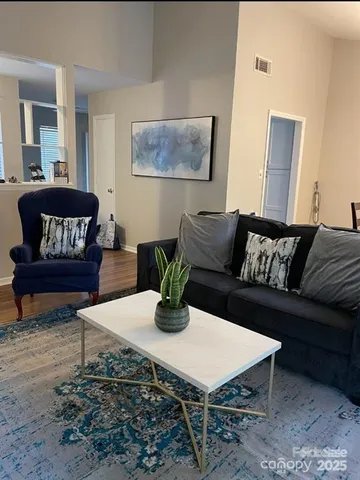 a living room with furniture and wooden floor