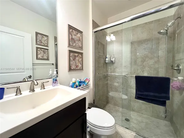 a bathroom with a sink a toilet and shower