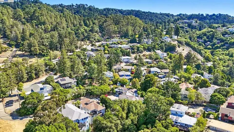 an aerial view of residential houses with outdoor space and street view