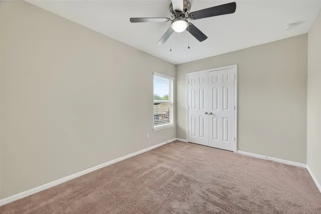 an empty room with fan and windows