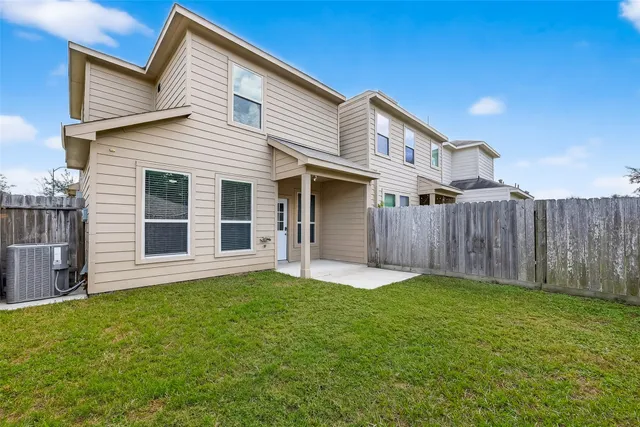 a view of a house with a yard and wooden fence