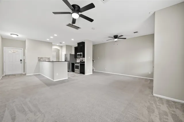 a view of a kitchen with a refrigerator and a ceiling fan