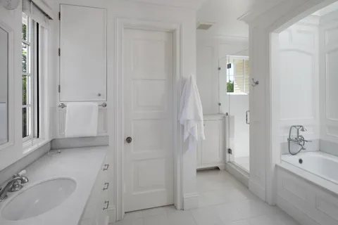 a bathroom with a tub sink and mirror