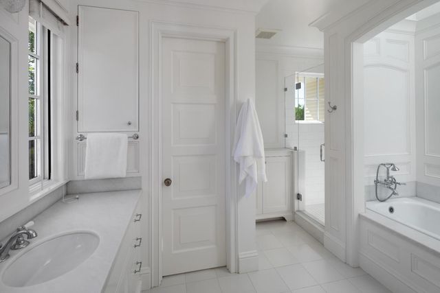 a bathroom with a tub sink and mirror
