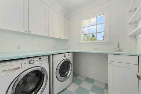 a utility room with sink dryer and washer