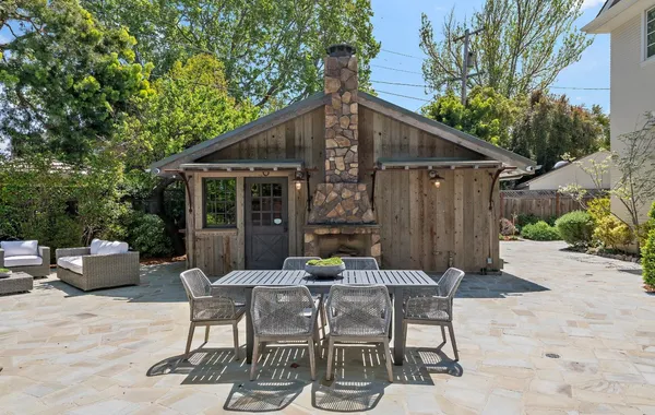 a view of a patio with a dining table and chairs with wooden fence