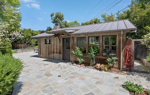 a view of a house with wooden walls and a yard