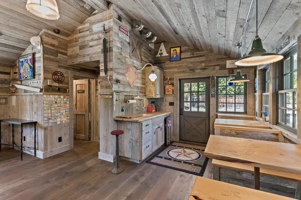 a kitchen with stainless steel appliances kitchen island granite countertop a table chairs and a refrigerator
