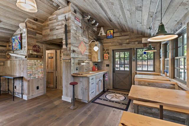 a kitchen with stainless steel appliances kitchen island granite countertop a table chairs and a refrigerator