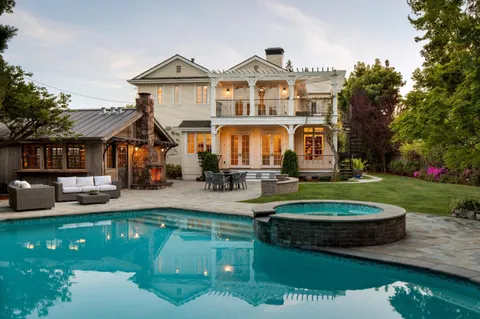 a front view of a house with a garden and trees