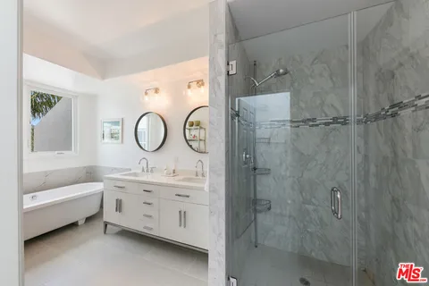 a bathroom with a double vanity sink mirror bathtub and shower