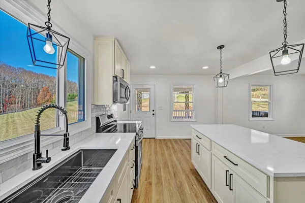 a spacious bathroom with a granite countertop double vanity sink a mirror and a bathtub