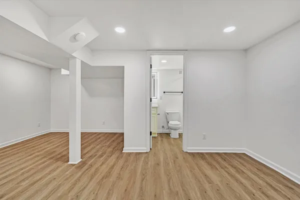 a view of empty room with wooden floor