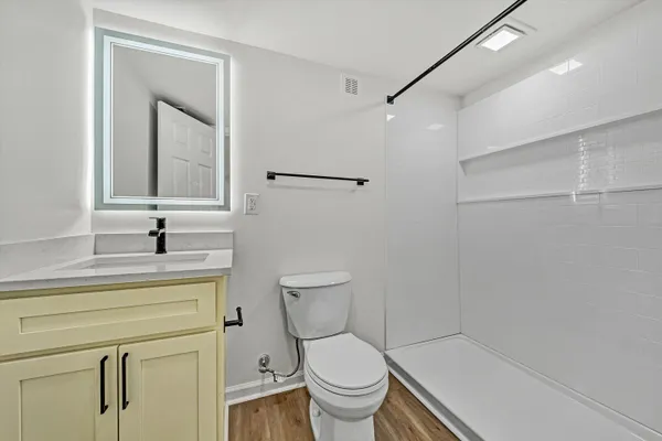 a bathroom with a toilet a sink and a mirror