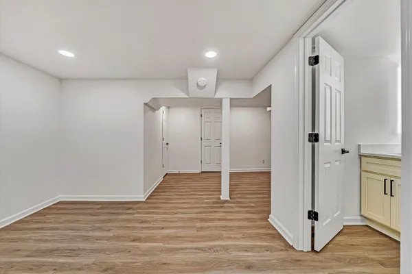 a view of a hallway with wooden floor and a ceiling fan