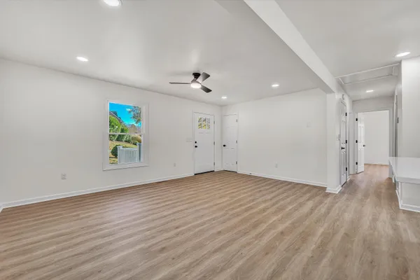 an empty room with window and a ceiling fan