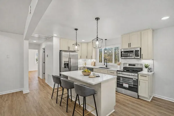a kitchen with stainless steel appliances granite countertop a stove refrigerator and a sink
