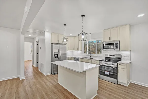 a large kitchen with stainless steel appliances granite countertop a stove and a refrigerator