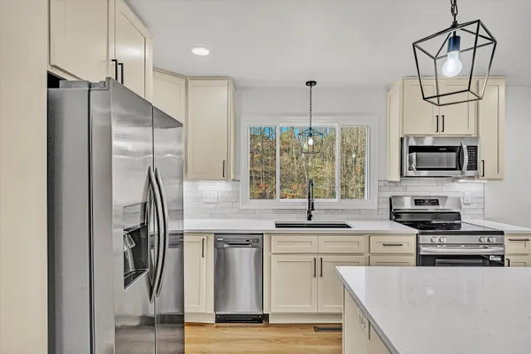a kitchen with stainless steel appliances a refrigerator sink and microwave