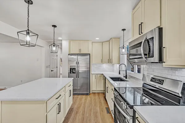a kitchen with stainless steel appliances a sink microwave and refrigerator