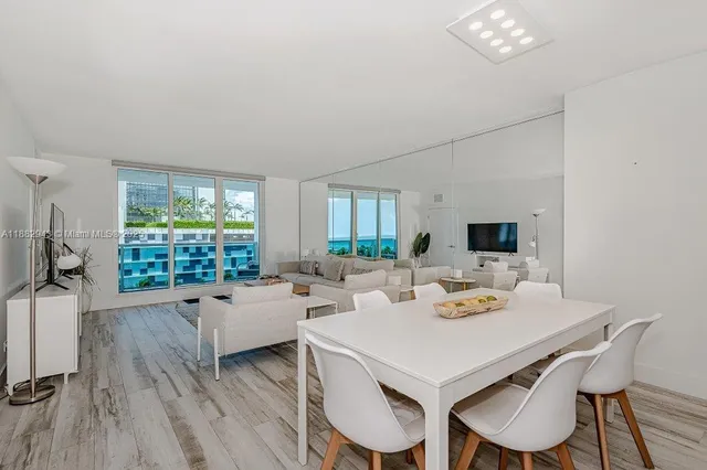 a view of a dining room with furniture a chandelier and wooden floor