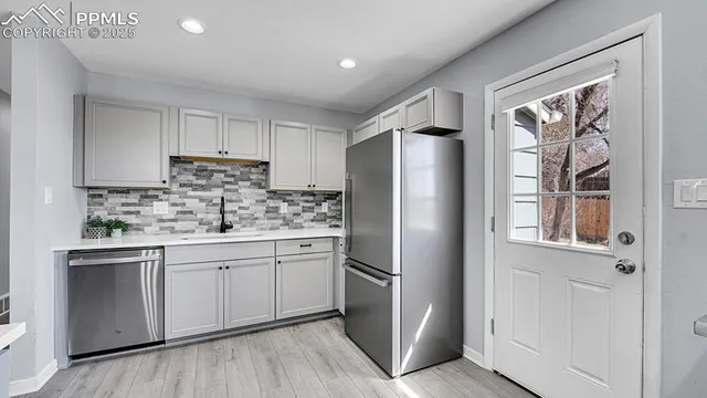 a kitchen with stainless steel appliances a refrigerator sink and cabinets