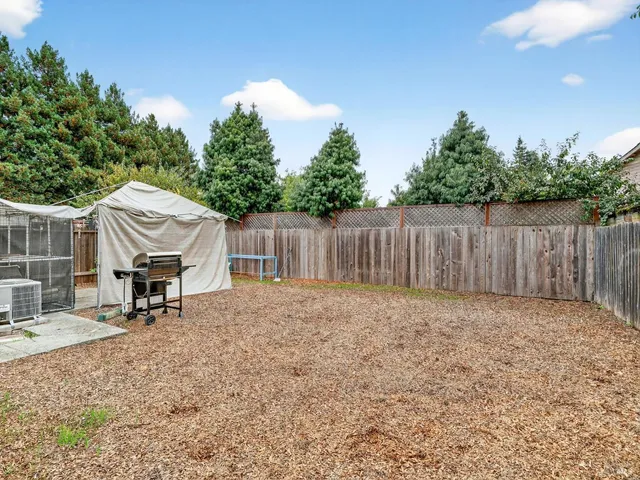 a backyard of a house with table and chairs