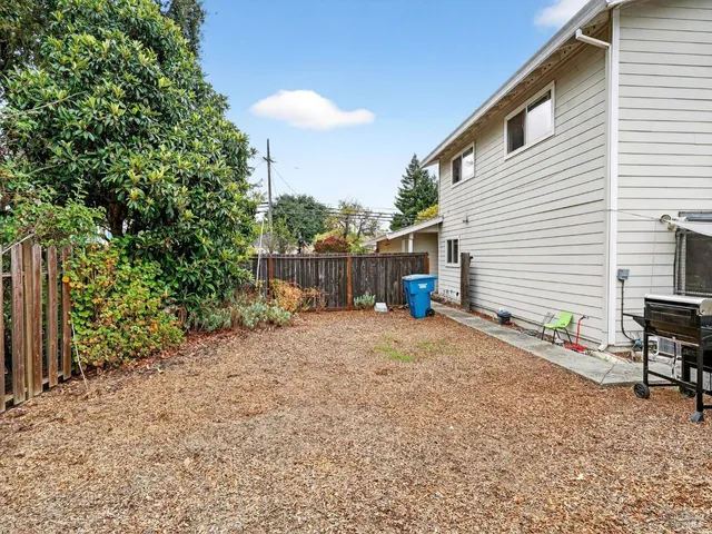 a backyard of a house with table and chairs