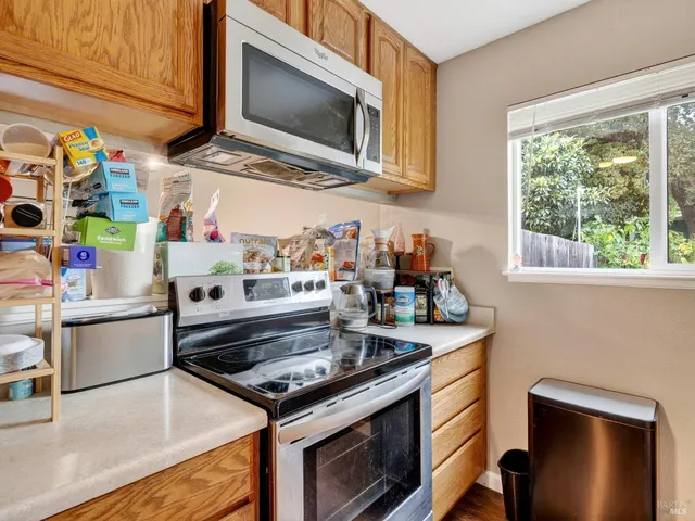 a kitchen with stainless steel appliances granite countertop a stove microwave and sink
