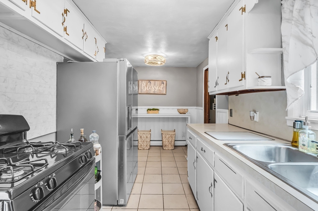 a kitchen with a sink stove top oven and cabinets