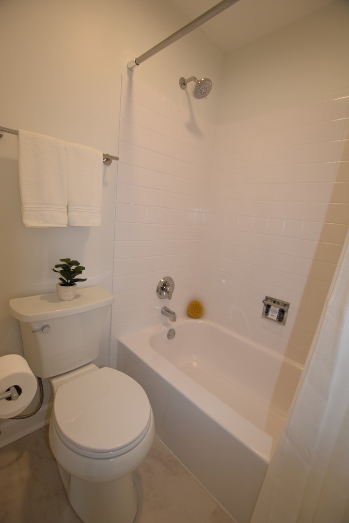 500 West Huntington Commons Road, Unit 157 Mount Prospect, IL 60056 - Photo 17 of 24 a white toilet sitting next to a bath tub