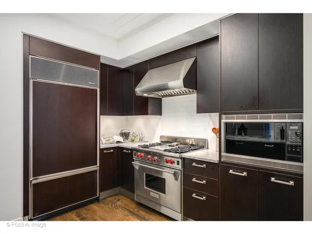 a kitchen with stainless steel appliances granite countertop a stove a refrigerator and a microwave