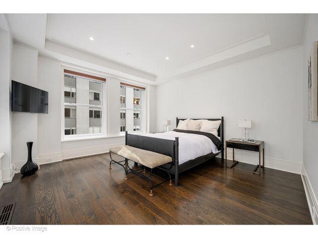 a bed room with a bed tv and a window